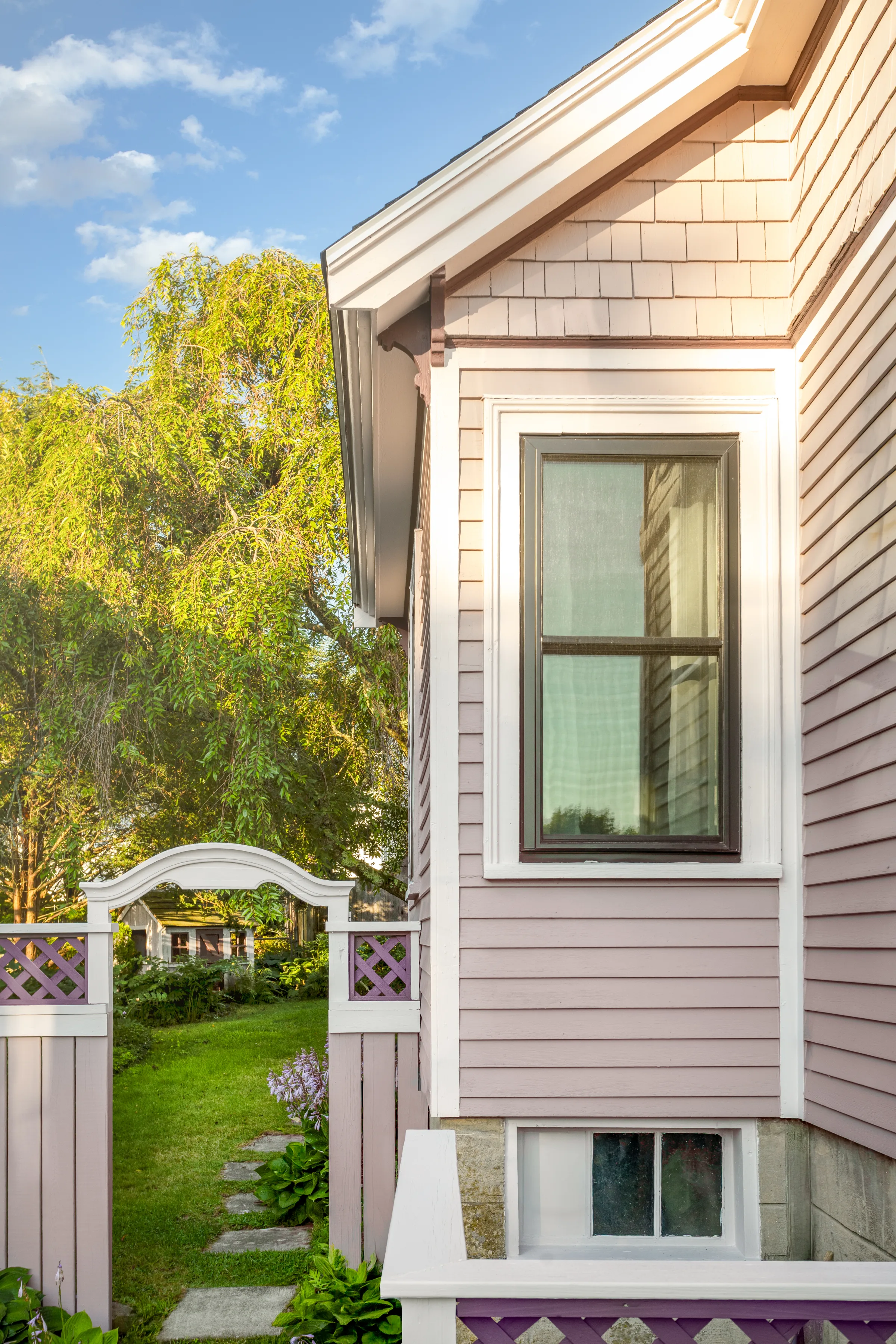 Window, gable trim, corbel, and garden gate in coordinated mauve, light, and purple colors